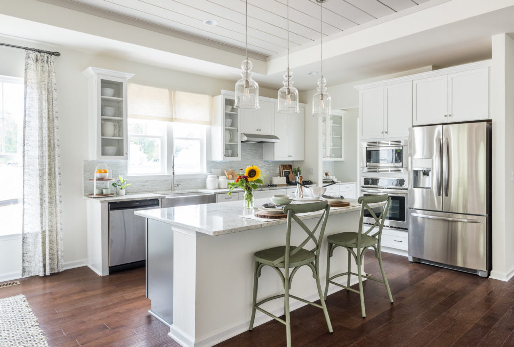 model home kitchen stainless steal white backsplash hardwood floors 55+ living